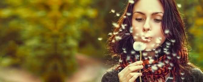 Woman blowing on a dandylion