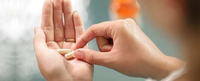 Woman taking supplement pill