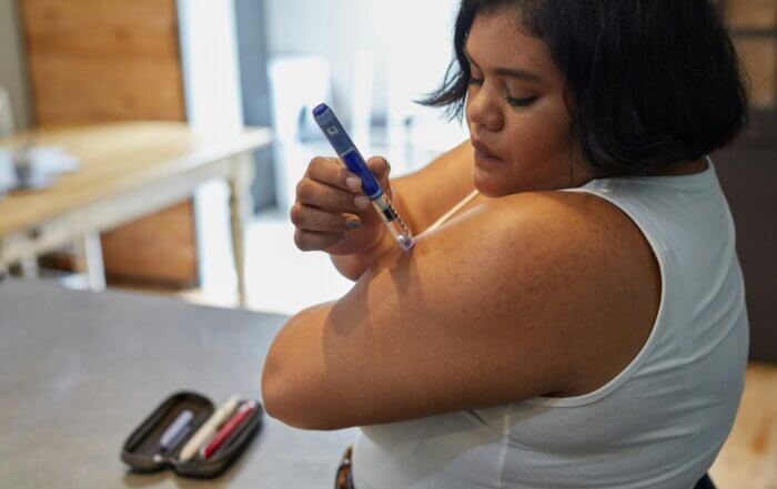 A woman using an insulin pen