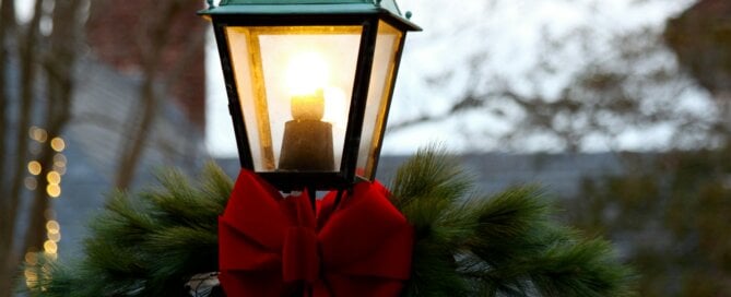 A street lamp decorated with a wreath and bow