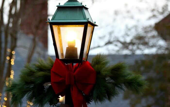 A street lamp decorated with a wreath and bow