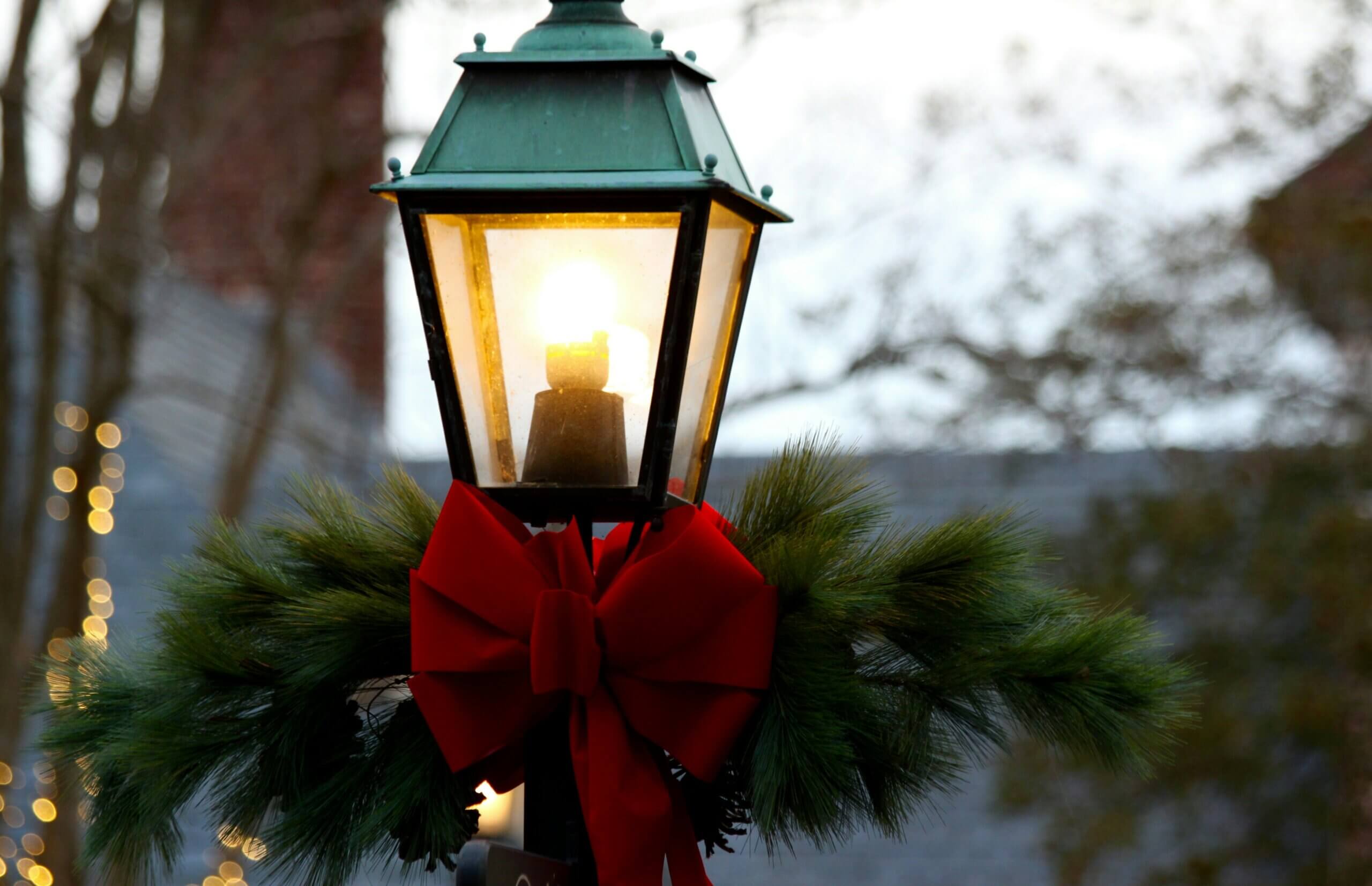 A street lamp decorated with a wreath and bow